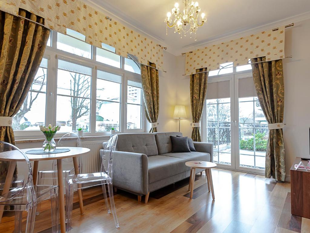 una sala de estar con un sofá y una mesa en VacationClub - Trzy Korony Wazów Apartment 11, en Świnoujście