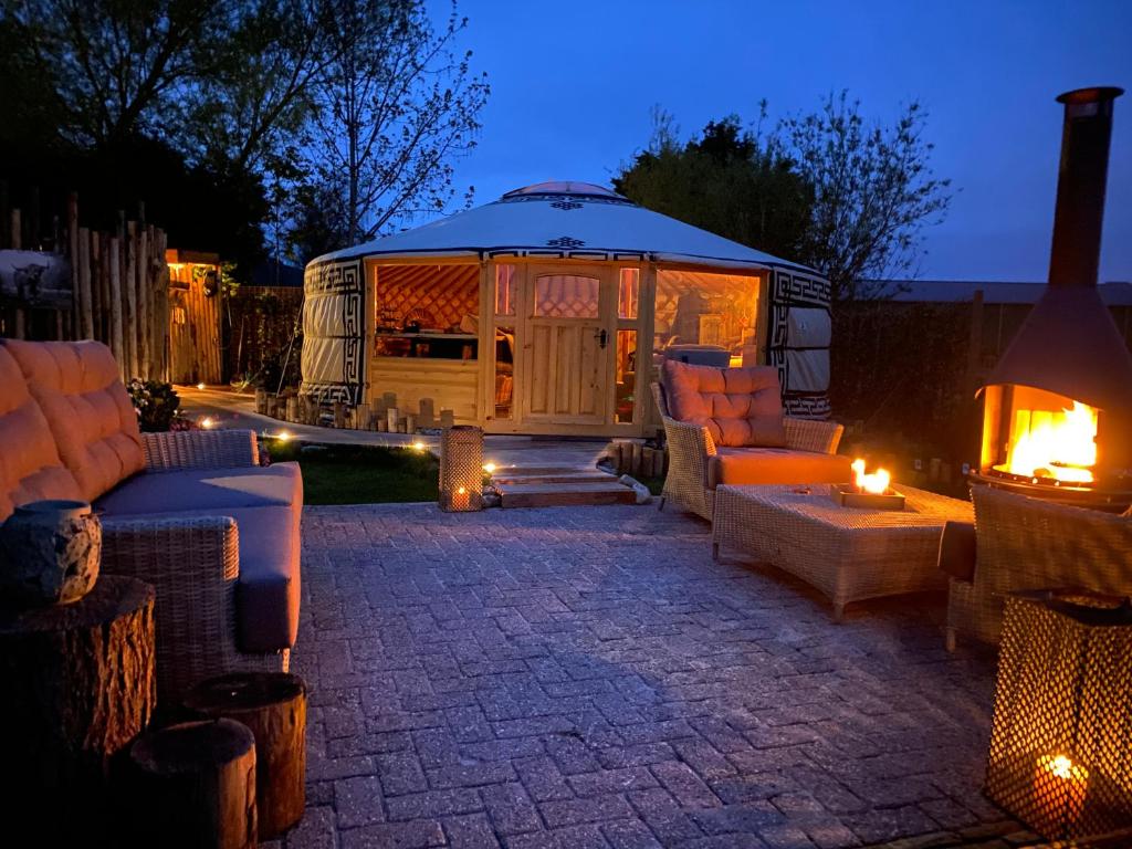 a backyard patio with couches and a rv at night at Basic luxury yurt in Egmond aan den Hoef