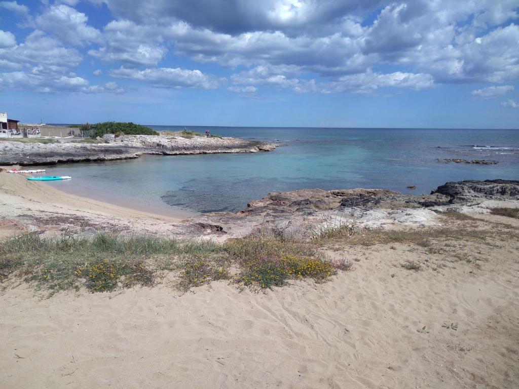 une plage avec des rochers et l'océan par une journée nuageuse dans l'établissement Casa al mare Ostuni camerini, à Villanova di Ostuni