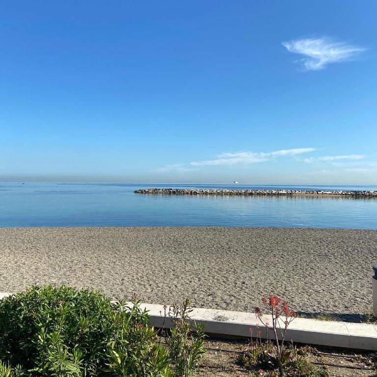 a sandy beach with a pier in the water at Bari Lory’s Home in Bari