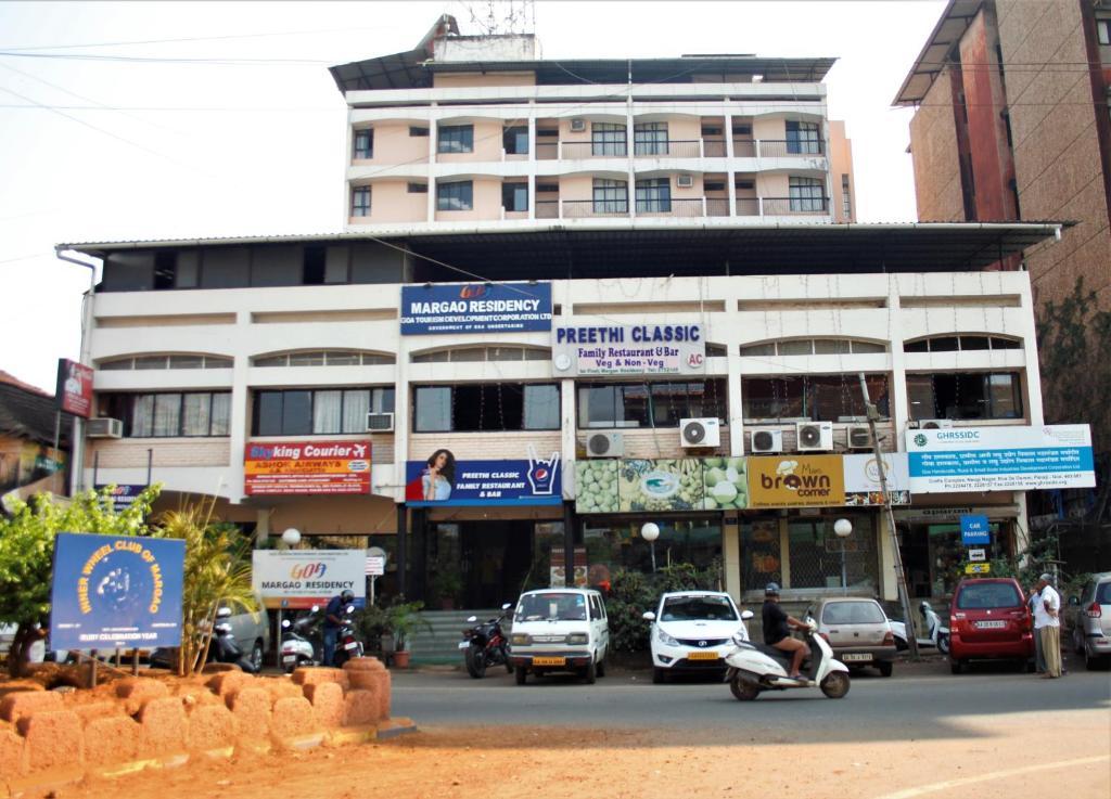 un edificio con coches y motocicletas en una calle de la ciudad en Margao Residency en Madgaon