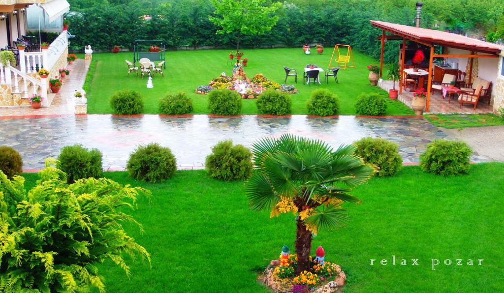 a garden with a palm tree in the grass at Relax pozar in Kato Loutraki