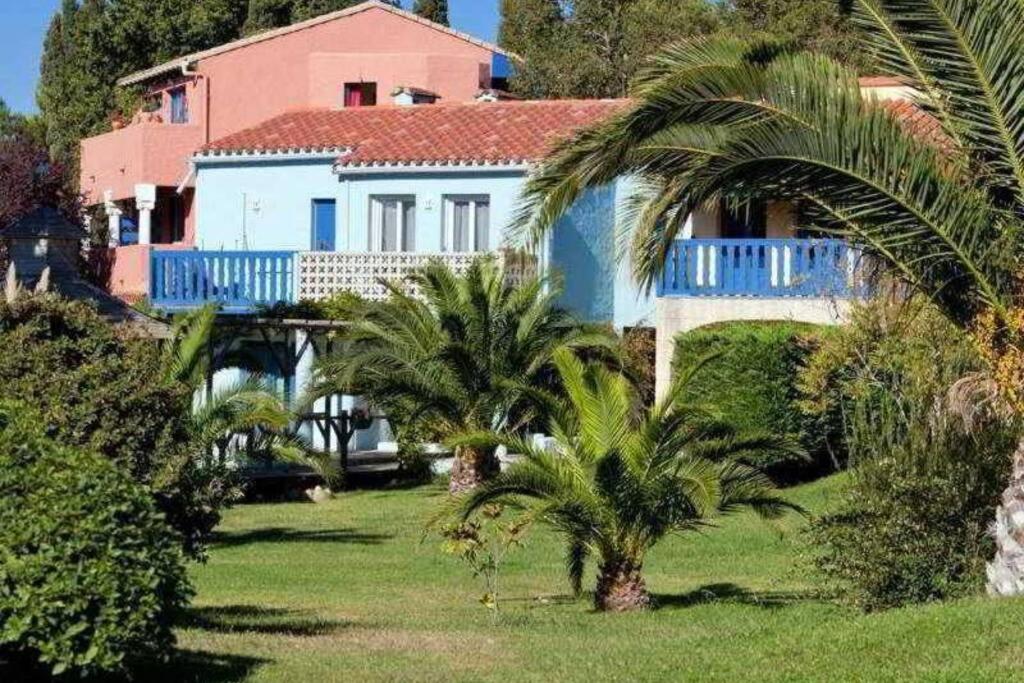 une maison avec des palmiers en face d'une cour dans l'établissement Appartement avec terrasse bodega, à Canet
