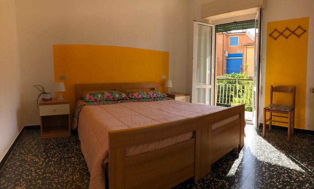 una camera con un grande letto e un balcone di Appartamento in pieno centro a 100m dal mare a Spotorno