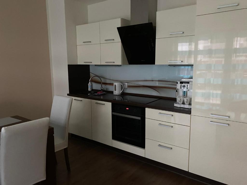 a kitchen with white cabinets and a black stove top oven at Apartament Morski in Świnoujście