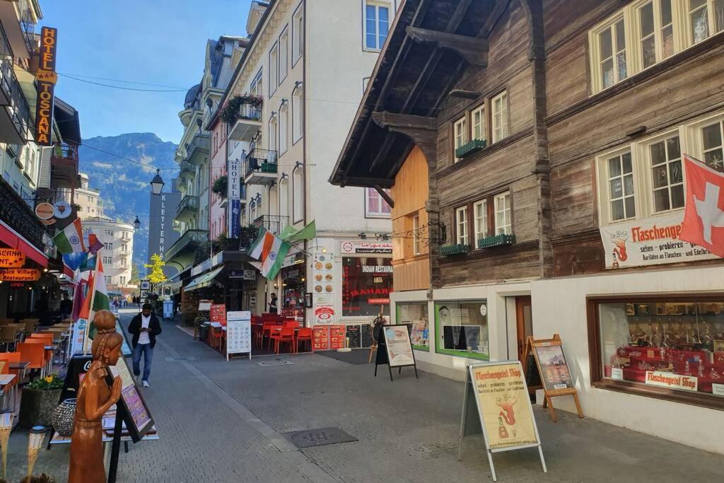 een vrouw die door een straat met gebouwen loopt bij Classy Apartment in Interlaken