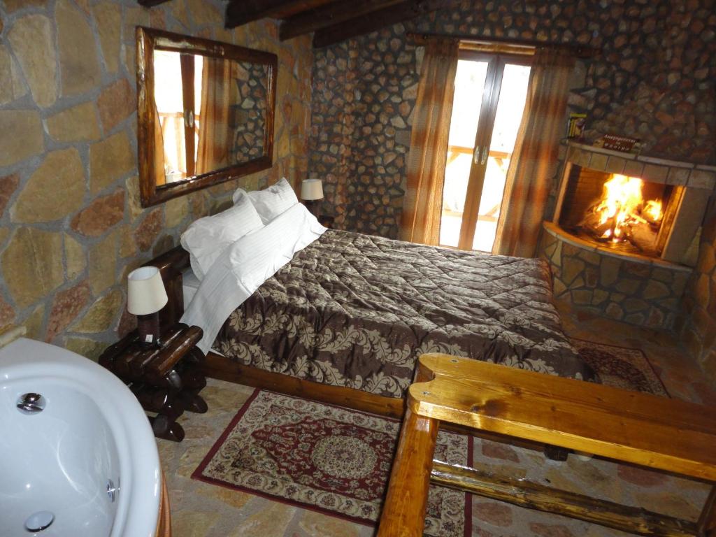 a bedroom with a bed with a fireplace and a sink at KALAVRITA INN in Kalavrita