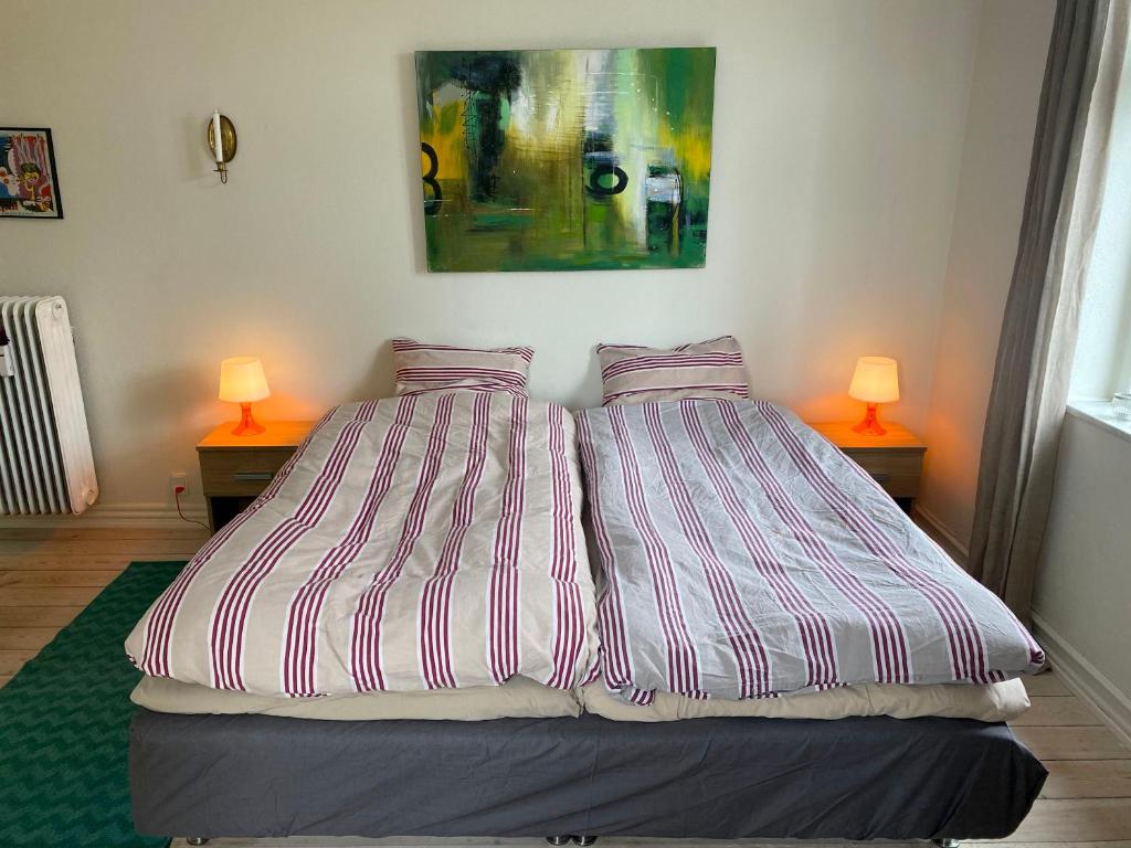 a bedroom with two beds and two lamps on two tables at Goodnight Randers in Randers