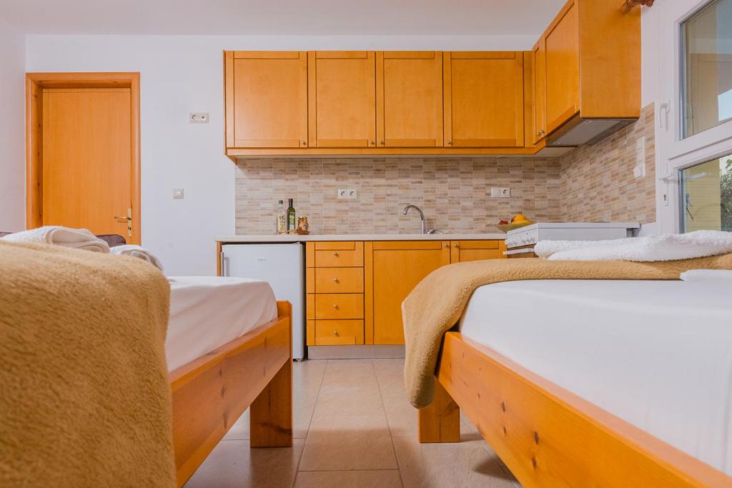 a kitchen with two beds and a sink in a room at Arsinoi Studios and Apartments in Kalamaki