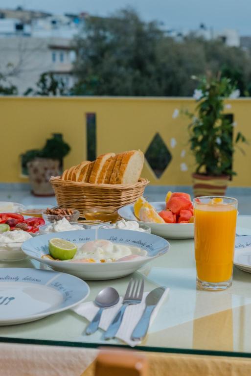 a table with plates of food and a basket of bread at Arsinoi Studios and Apartments in Kalamaki