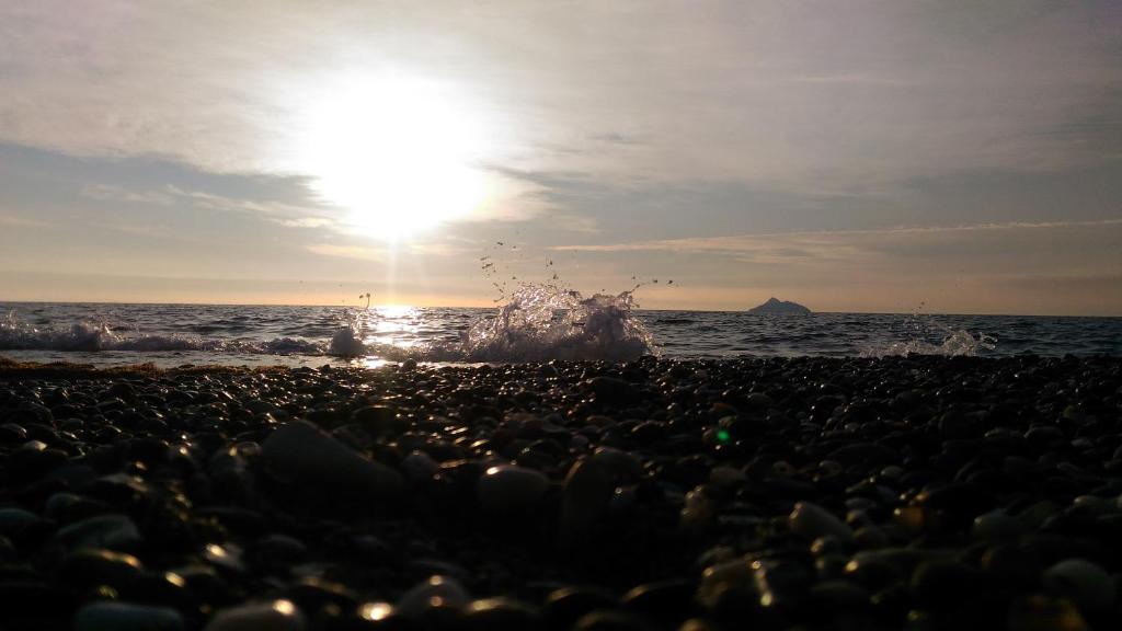 a group of people on a beach with the ocean at Arsinoi Studios and Apartments in Kalamaki