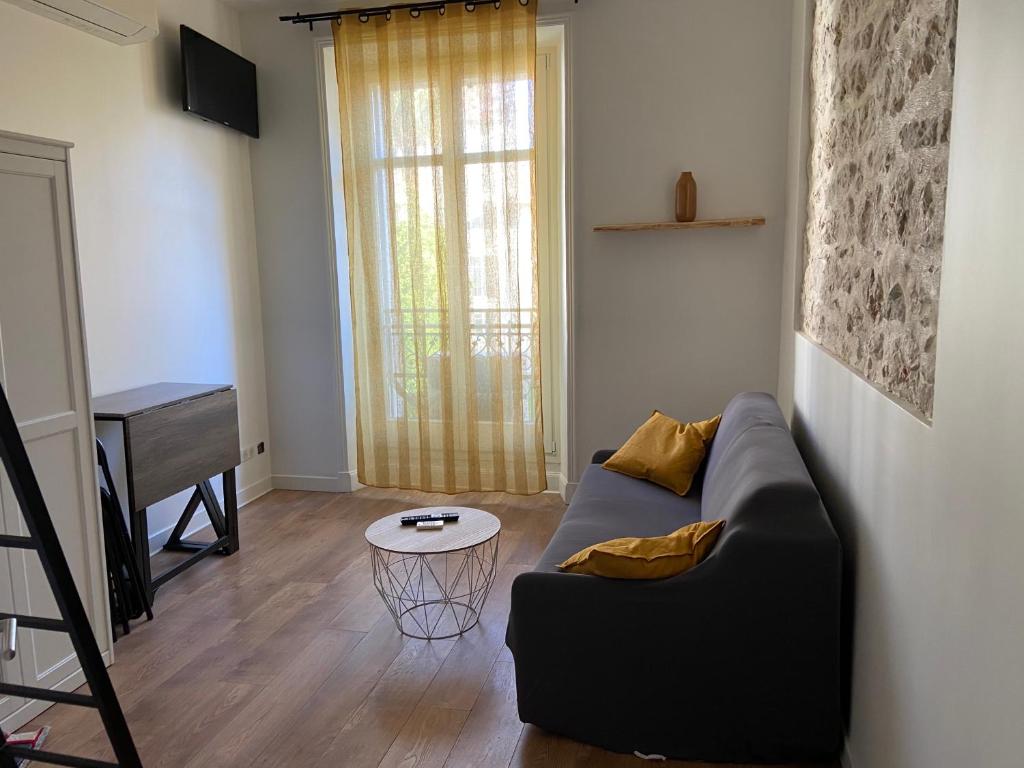 un salon avec un canapé et une table dans l'établissement Nice Centre: à 300m de la mer et de la Promenade des Anglais, à Nice