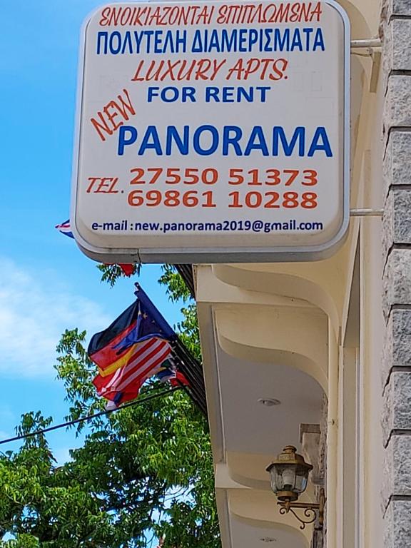 ein Schild für ein Restaurant in einem Gebäude mit einer Flagge in der Unterkunft NEW PANORAMA STUDIOS in Paralio Astros