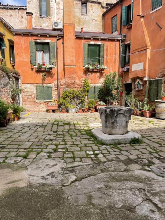 a stone courtyard with a planter in front of a building at Blusuite appartamento in Venice