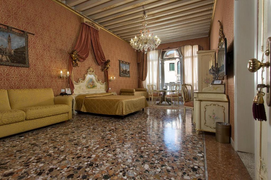 uma sala de estar com uma cama e um sofá num quarto em Locanda Cà Le Vele em Veneza