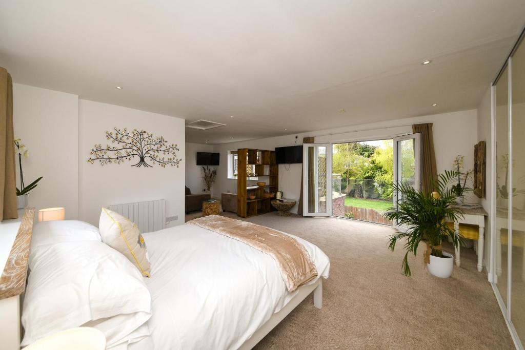 a bedroom with a white bed and a large window at Lakeside Old Hunstanton in Hunstanton