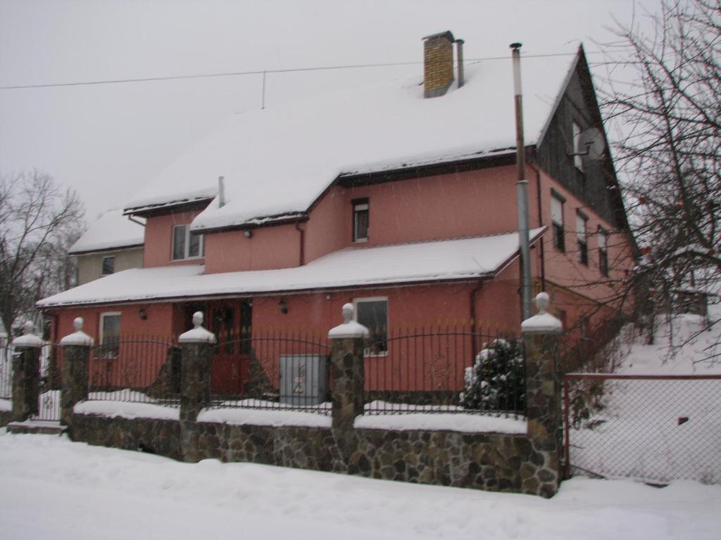 a red barn with snow on top of it at гостинна ВАША ХАТА in Volovets