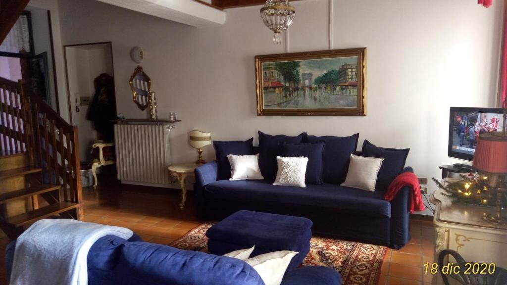 a living room with a blue couch and a table at Appartamento Piuisna in Iseo