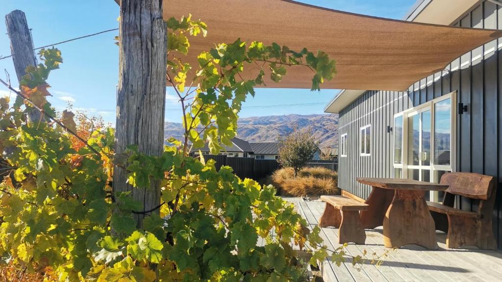 a patio with a wooden pergola and a picnic table at Cromwell Safari Bach in Cromwell