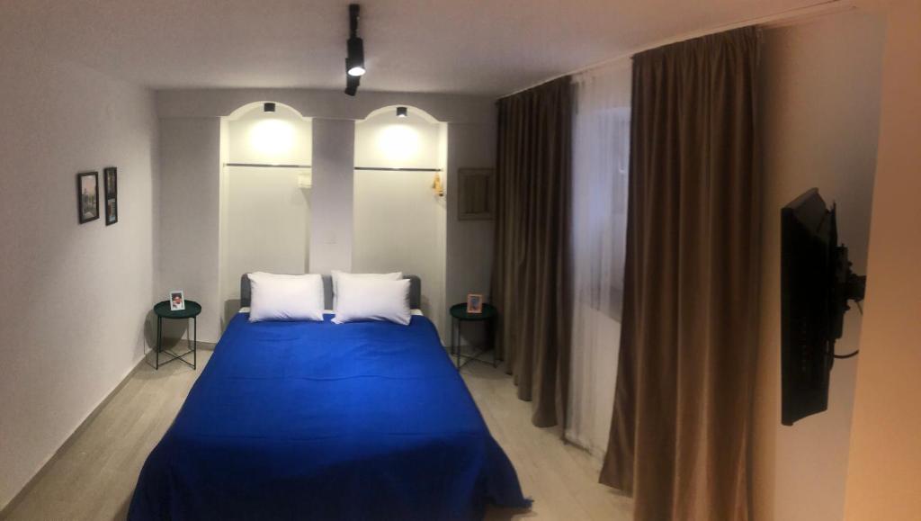um quarto com uma cama azul e 2 almofadas em City Centre One em Skopje