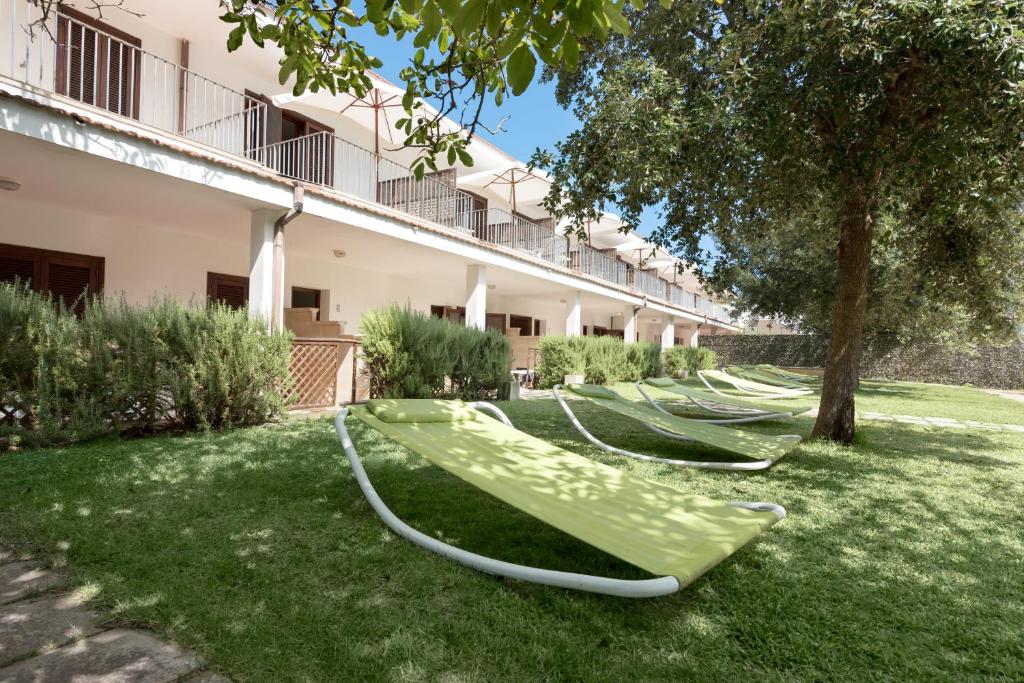 a row of green lawn chairs in a yard at Residence Costa d’Otranto in Otranto
