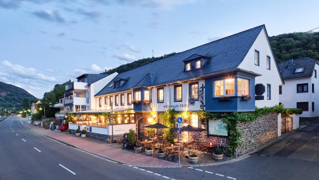 un grand bâtiment sur le côté d'une rue dans l'établissement Weinhaus Fries, à Kattenes