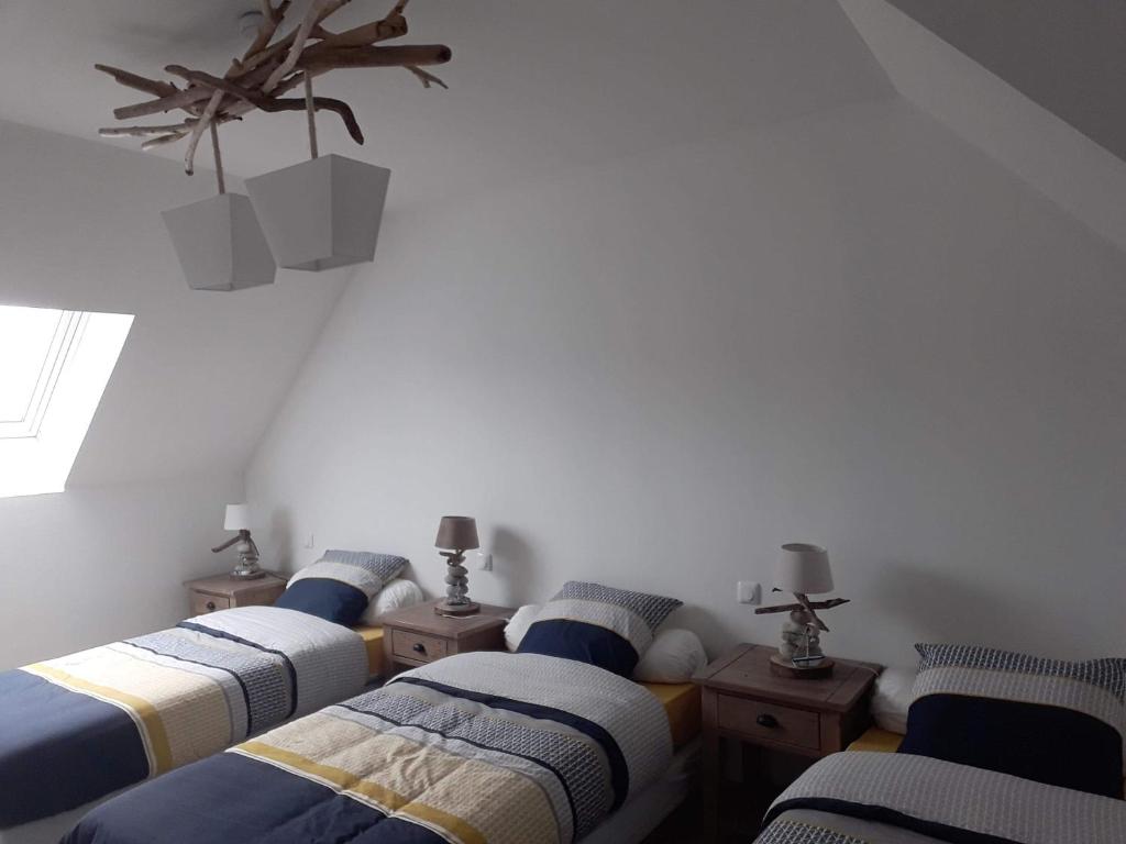 a group of four beds in a room at Le Chant des Vagues in Audinghen