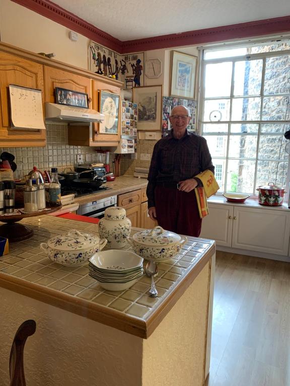 a man standing in a kitchen with a counter at geraldsplace in Edinburgh