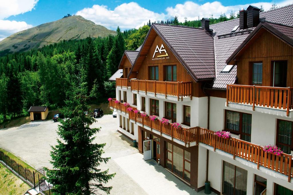 ein Apartmenthaus mit einem Berg im Hintergrund in der Unterkunft Hotel Rezydencja AS & Spa-Najwyżej w Karpaczu in Karpacz