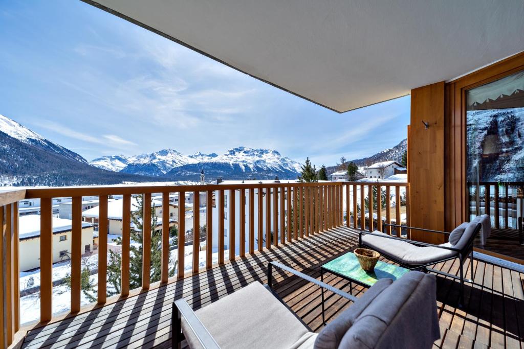 einen Balkon mit Blick auf die schneebedeckten Berge in der Unterkunft Sur Puoz 13 - Samedan in Samedan