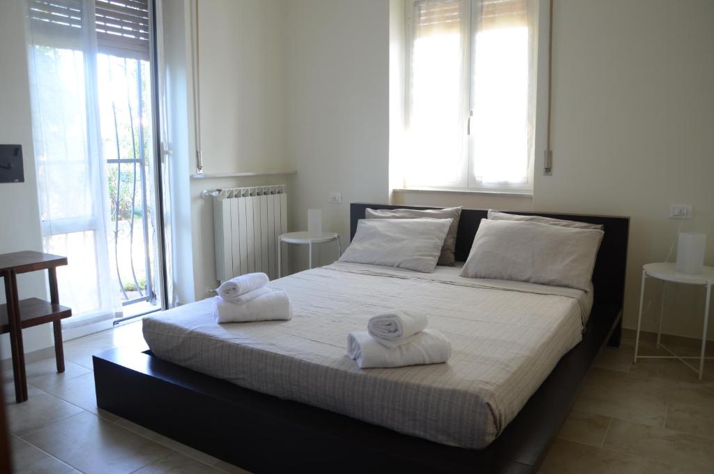 a bedroom with a large bed with towels on it at Calicantus bed and breakfast in Albenga