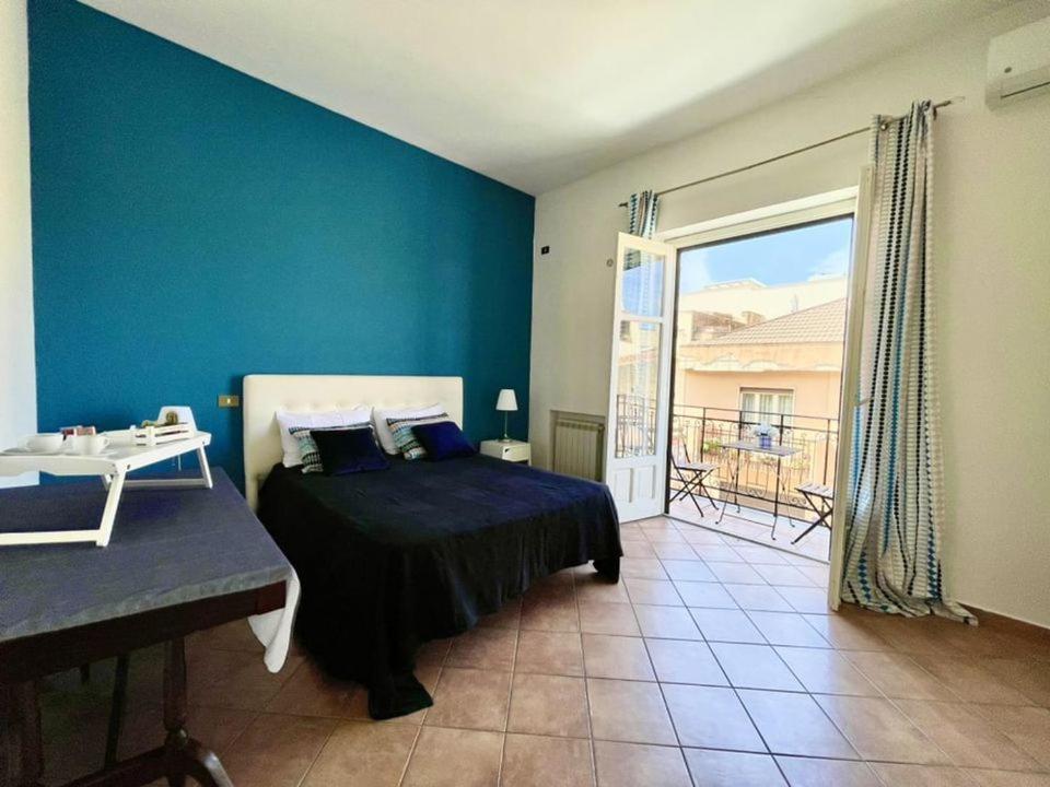 um quarto com uma cama e uma parede azul em Apartment in the center em Terrasini