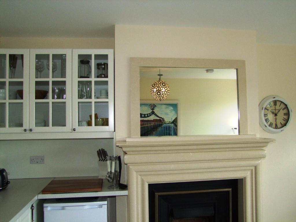 een woonkamer met een open haard en een spiegel bij Glendalough 11 Minutes from Beautiful Farmhouse Apartment in Wicklow