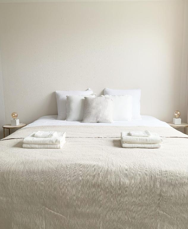 een wit bed met twee witte kussens erop bij Sea you soon in Den Burg
