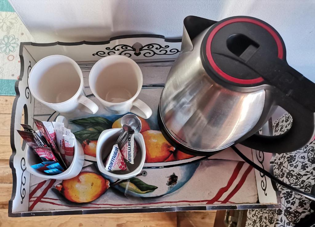 una tetera y tazas en una bandeja con fruta en Chilli Moon B&B, en Stilbaai