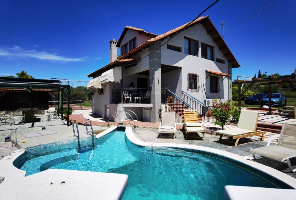 eine Villa mit einem Pool vor einem Haus in der Unterkunft Rural villa Private pool, BBQ, court ,20' airport in Nea Kallikratia