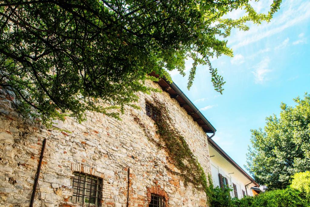 a brick building with a tree next to it at Palazzo Del Pero - The House Of Travelers in Como