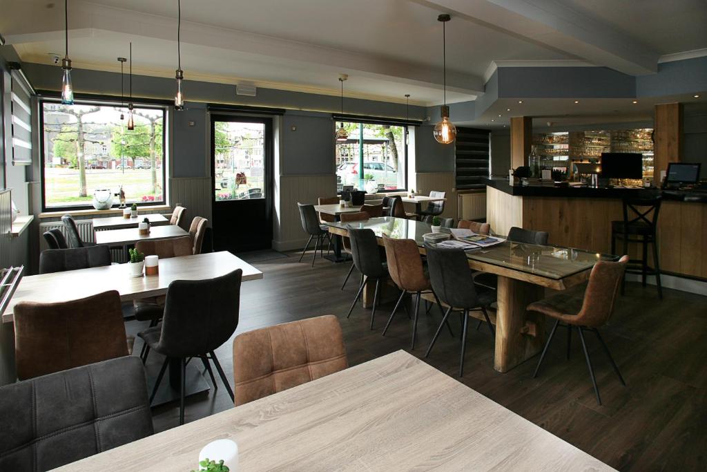 ein Restaurant mit Tischen und Stühlen und eine Bar in der Unterkunft Hotel Au Prince Royal in Leopoldsburg
