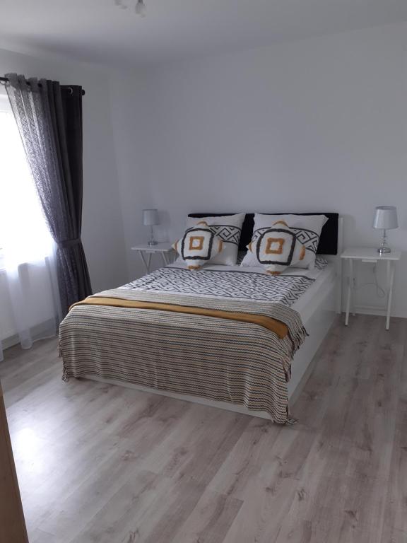 um quarto com uma cama grande e pisos em madeira em Noclegi U Janusza 536-310-384 em Polańczyk