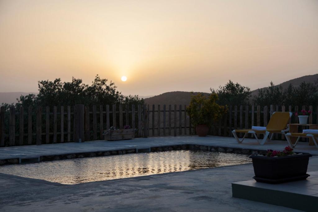 a backyard with a pool with the sunset in the background at Villa Filyra in Faraklata