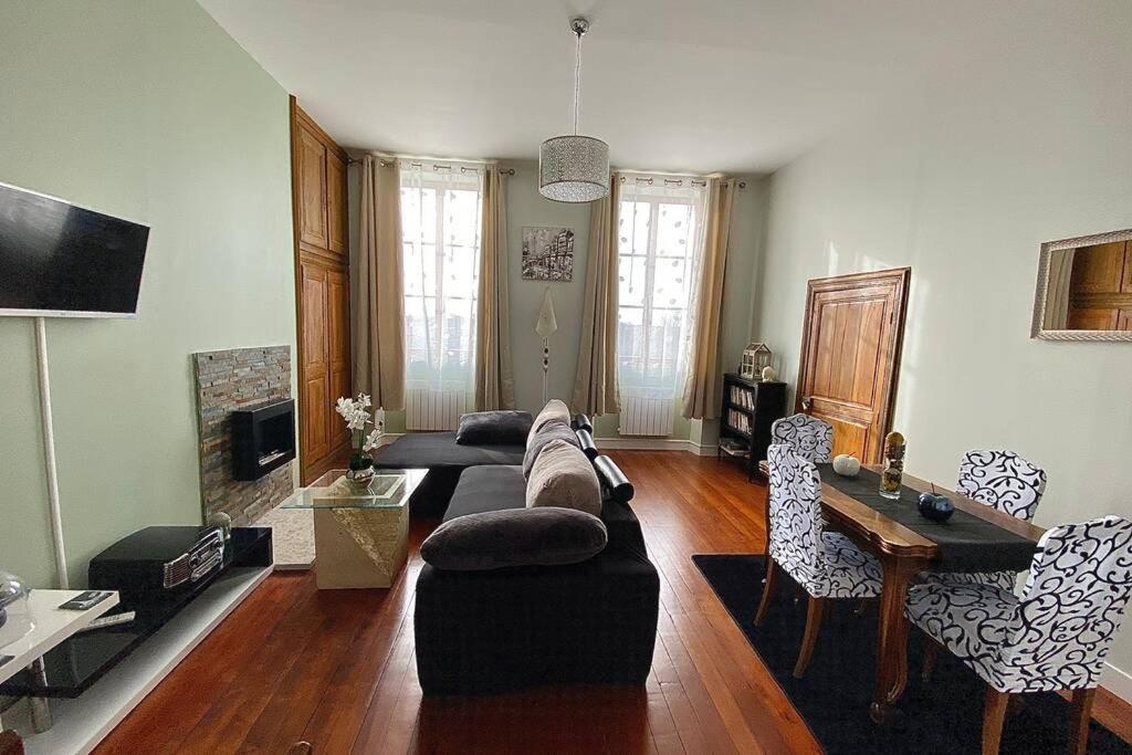 uma sala de estar com um sofá e uma mesa em Appartement : Le petit paradis de la Loire em Charité-sur-Loire