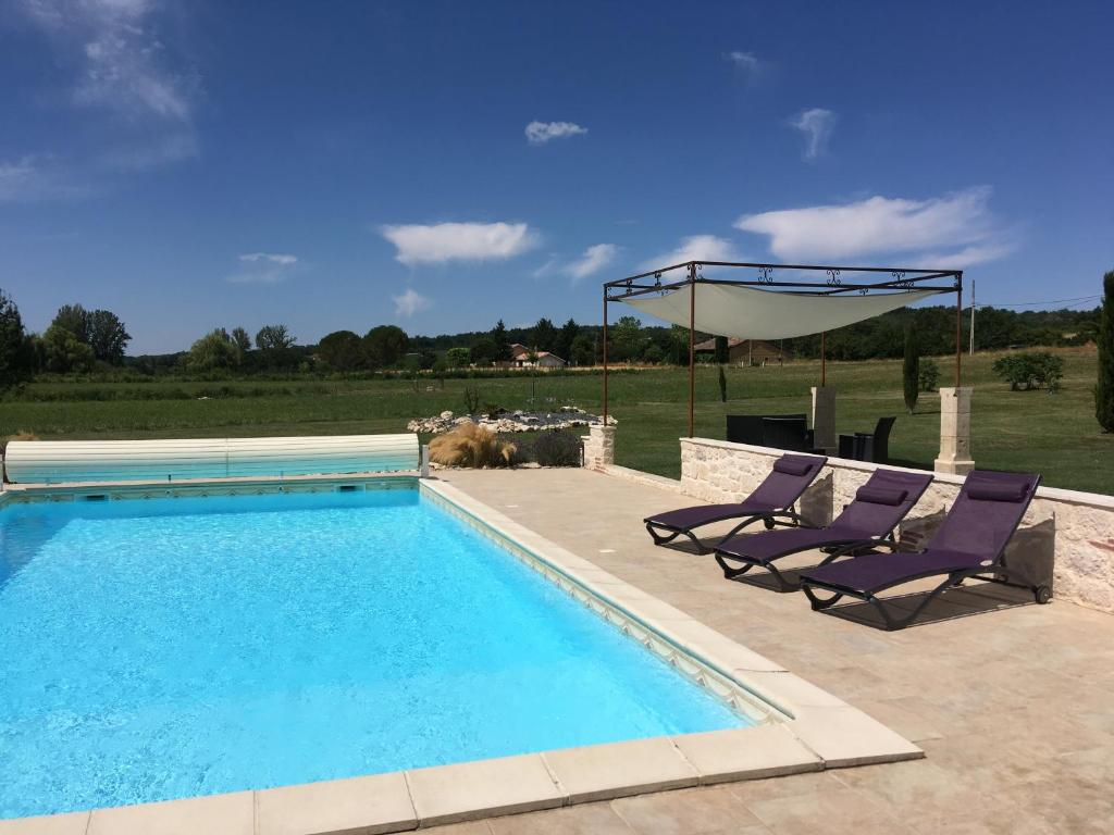 - une piscine avec 2 chaises longues à côté dans l'établissement Moulin de la Peyriere, à Cazes-Mondenard