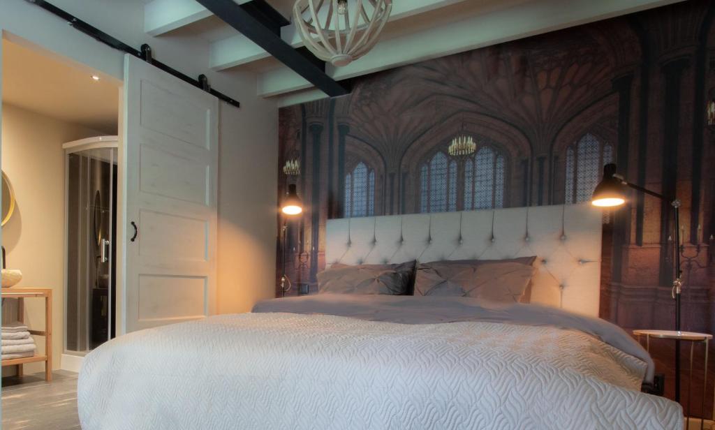 a bedroom with a large white bed with a ceiling at Bed & Breakfast Neeltje Soet in Mierlo