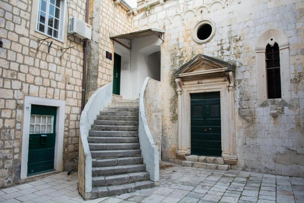 un edificio in pietra con scale che conducono a due porte di Room PlaceForYou a Dubrovnik