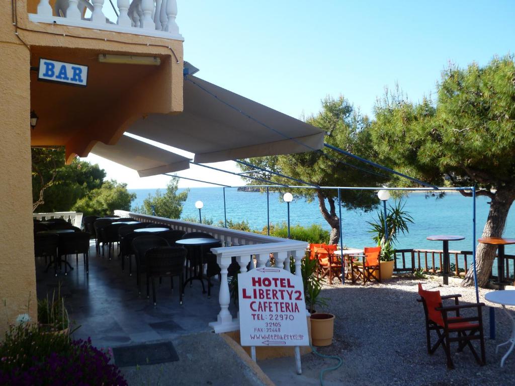 un restaurant avec des tables, des chaises et un panneau dans l'établissement Liberty II, à Agia Marina