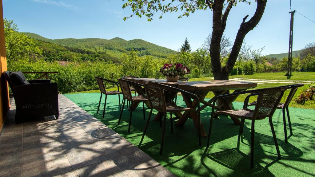 a table and chairs on a patio with mountains in the background at Dombtető Vendégház in Sátoraljaújhely