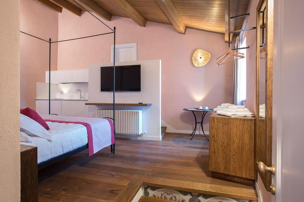 a bedroom with a bed and a tv on the wall at Dimora del Leone Gaeta in Gaeta