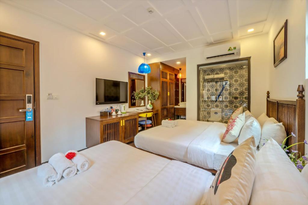 Postel nebo postele na pokoji v ubytování Son Trang Hotel Hoi An