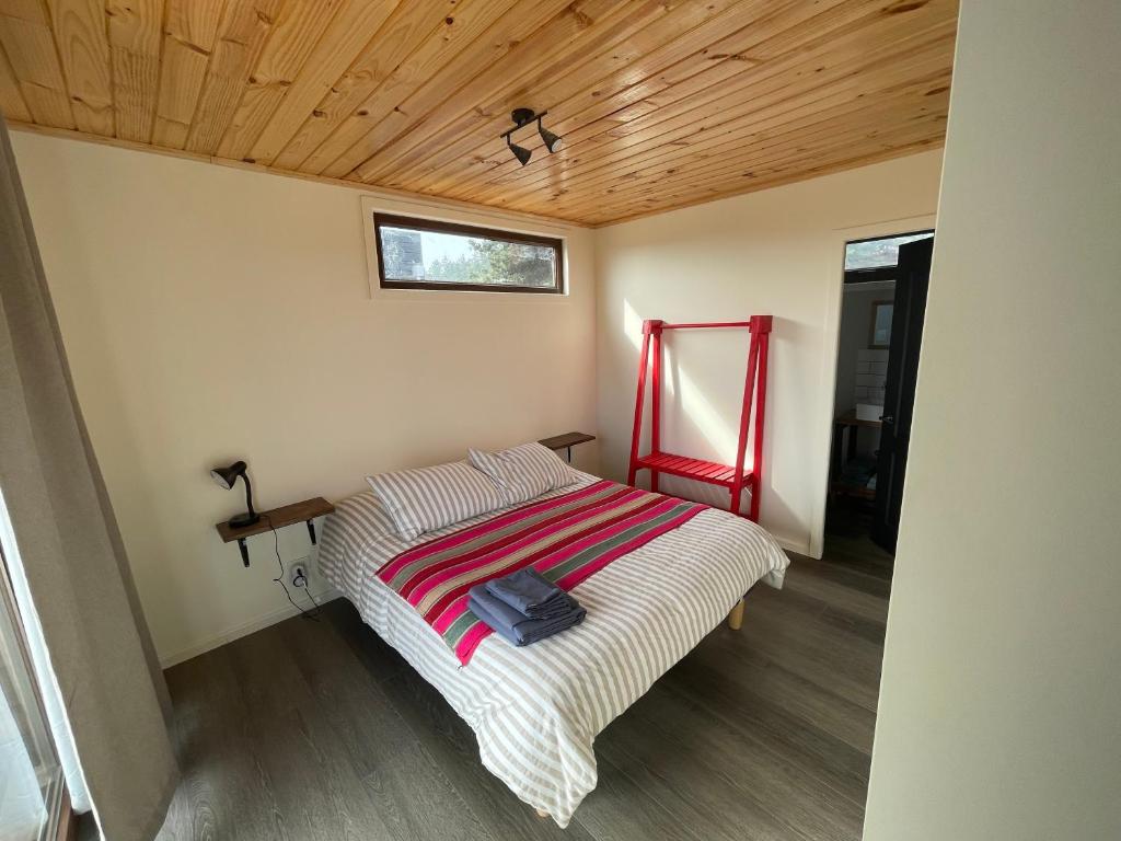 Bett in einem Zimmer mit Holzdecke in der Unterkunft Dunas de Cahuil in Pichilemu