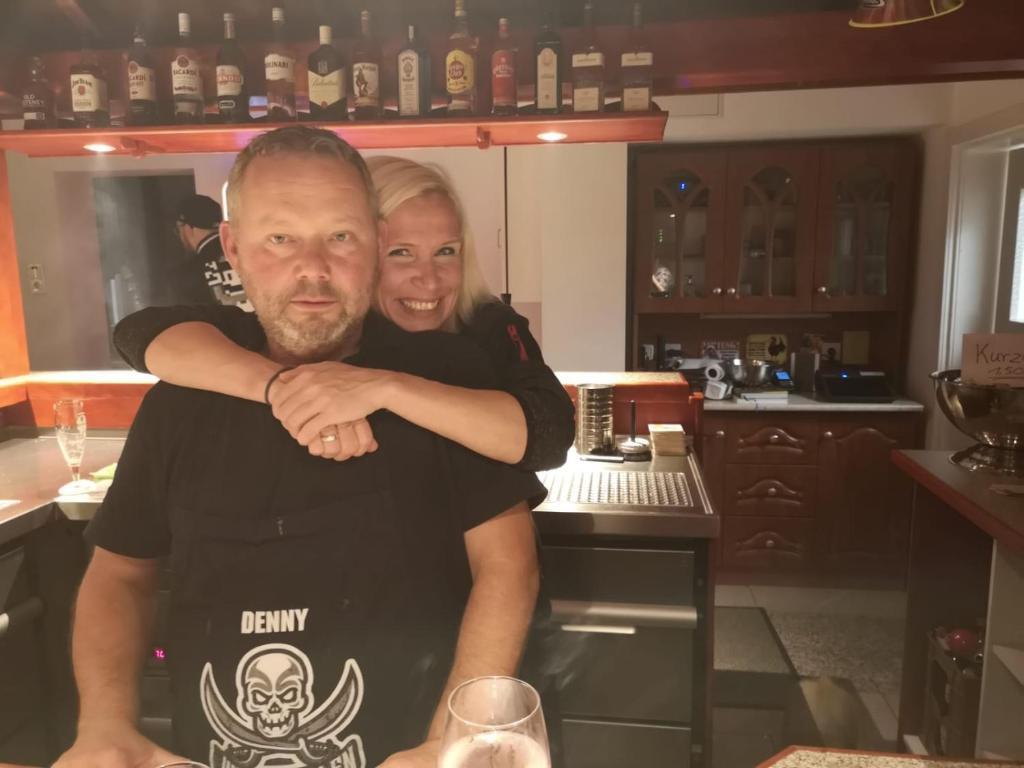 a man and a woman standing in a kitchen at Landhaus Wildemann in Wildemann